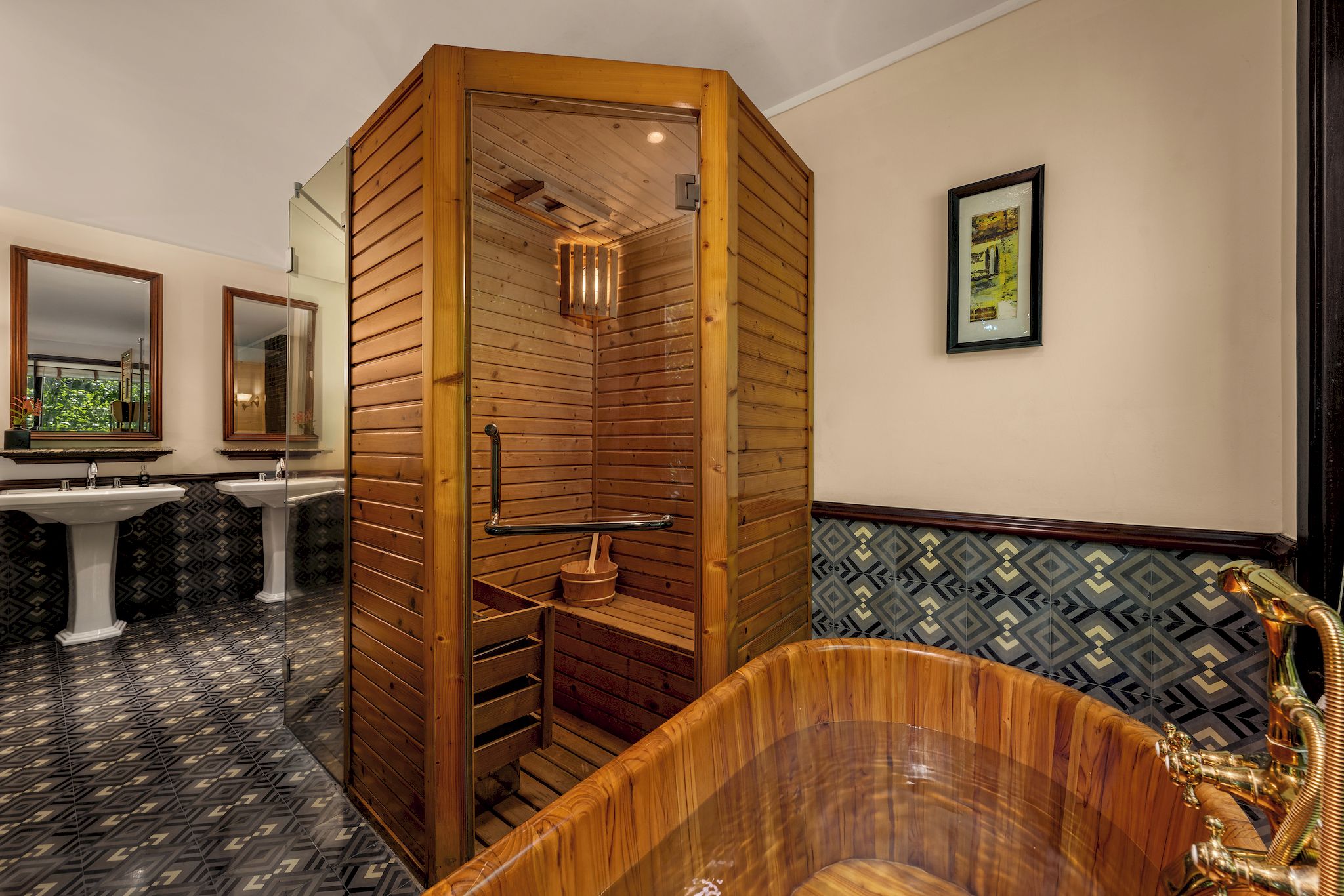 A sauna with wooden walls and a bench, a bathtub with a golden faucet, and two sinks with mirrors.