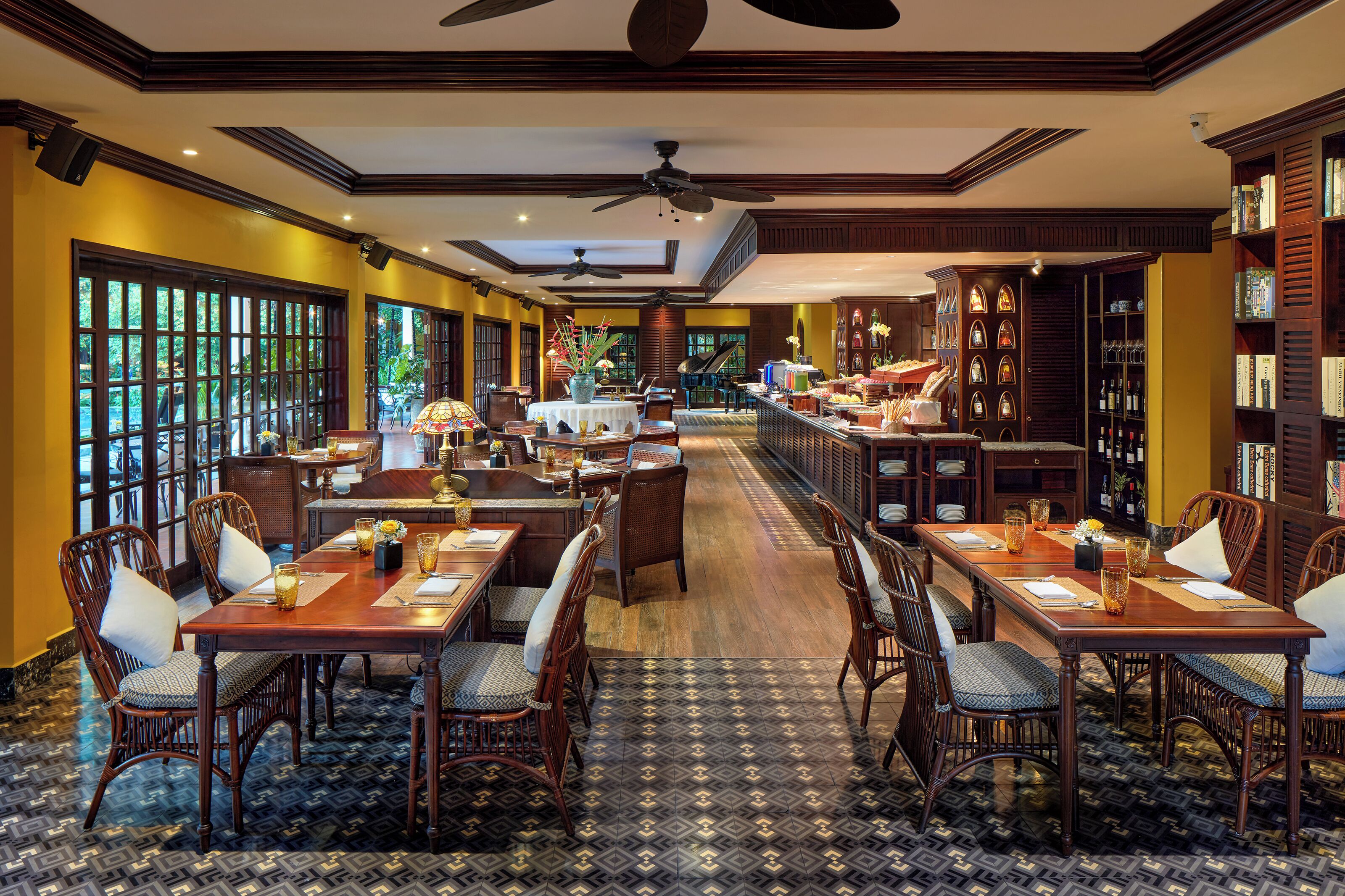 A spacious dining area with high ceilings, large windows, and a variety of seating arrangements.