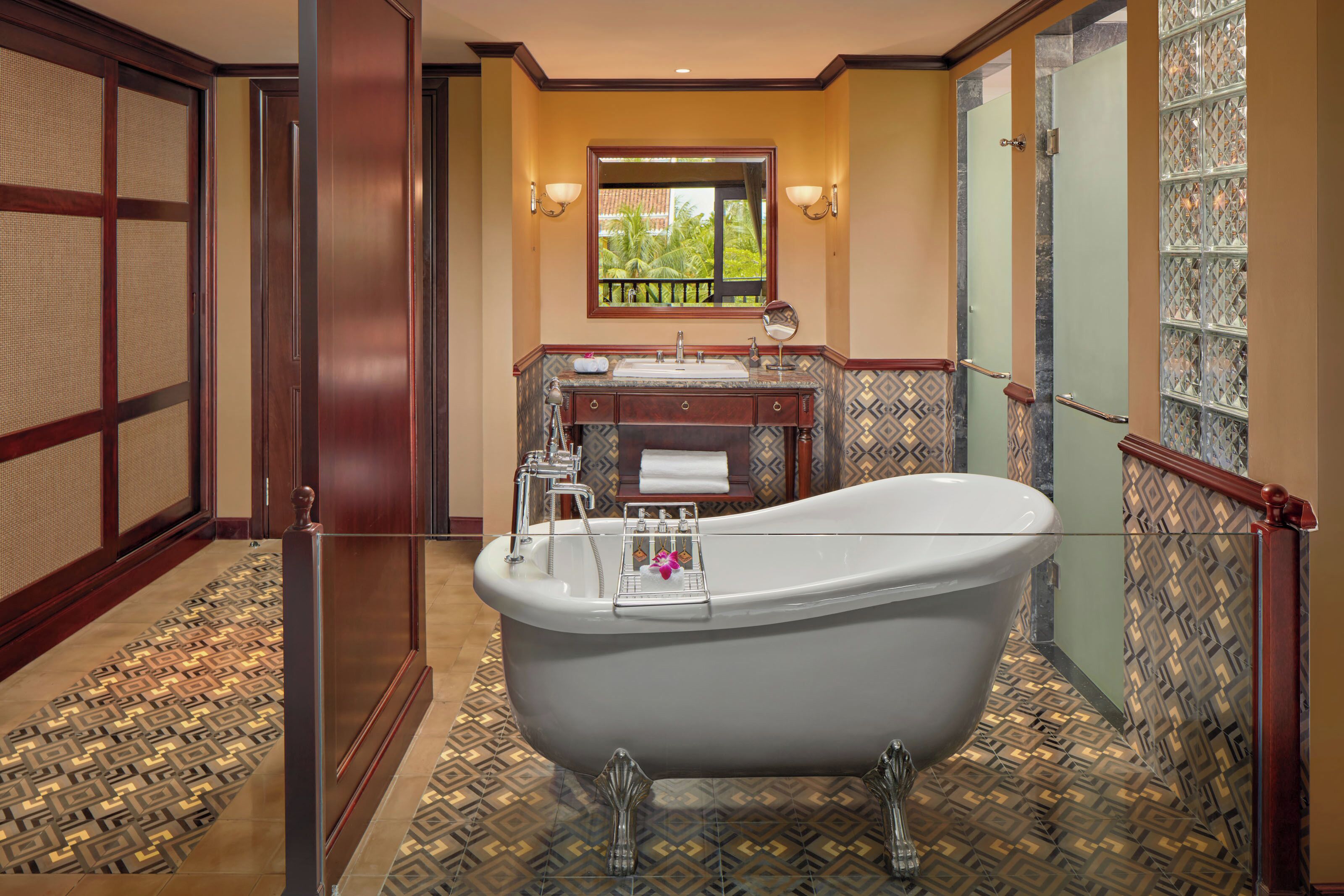Un baño con una bañera independiente, un lavabo y un espejo.