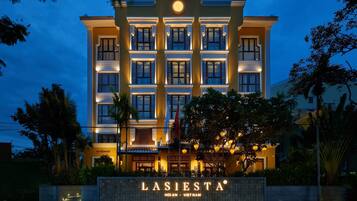 A hotel facade with a sign reading "LASIESTA HOIN - VIET NAM".