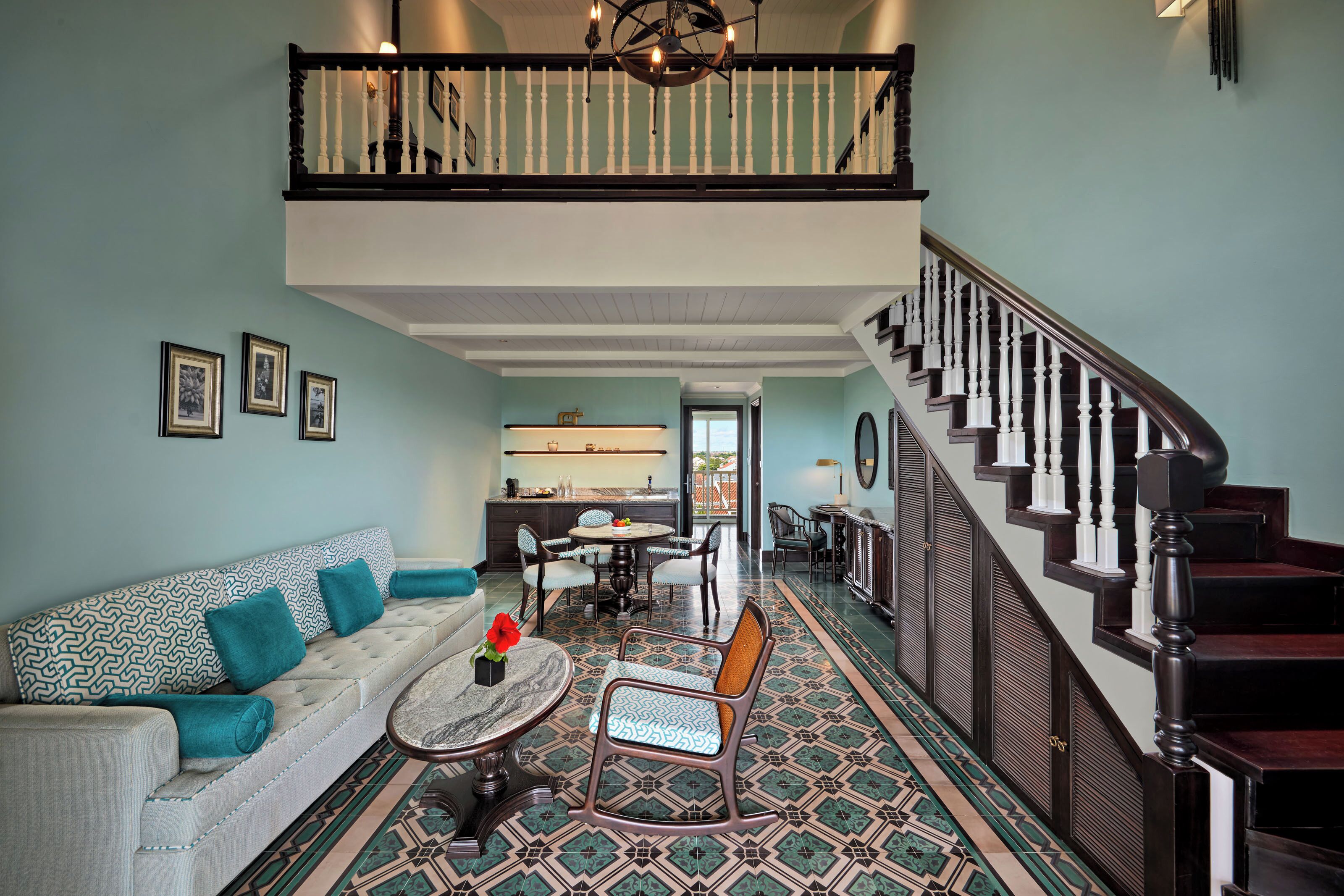 A spacious living room with a high ceiling, a staircase, and a dining area.