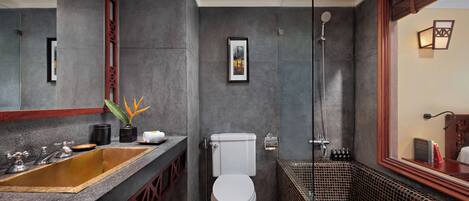 A modern bathroom with a large sink, toilet, and shower area.
