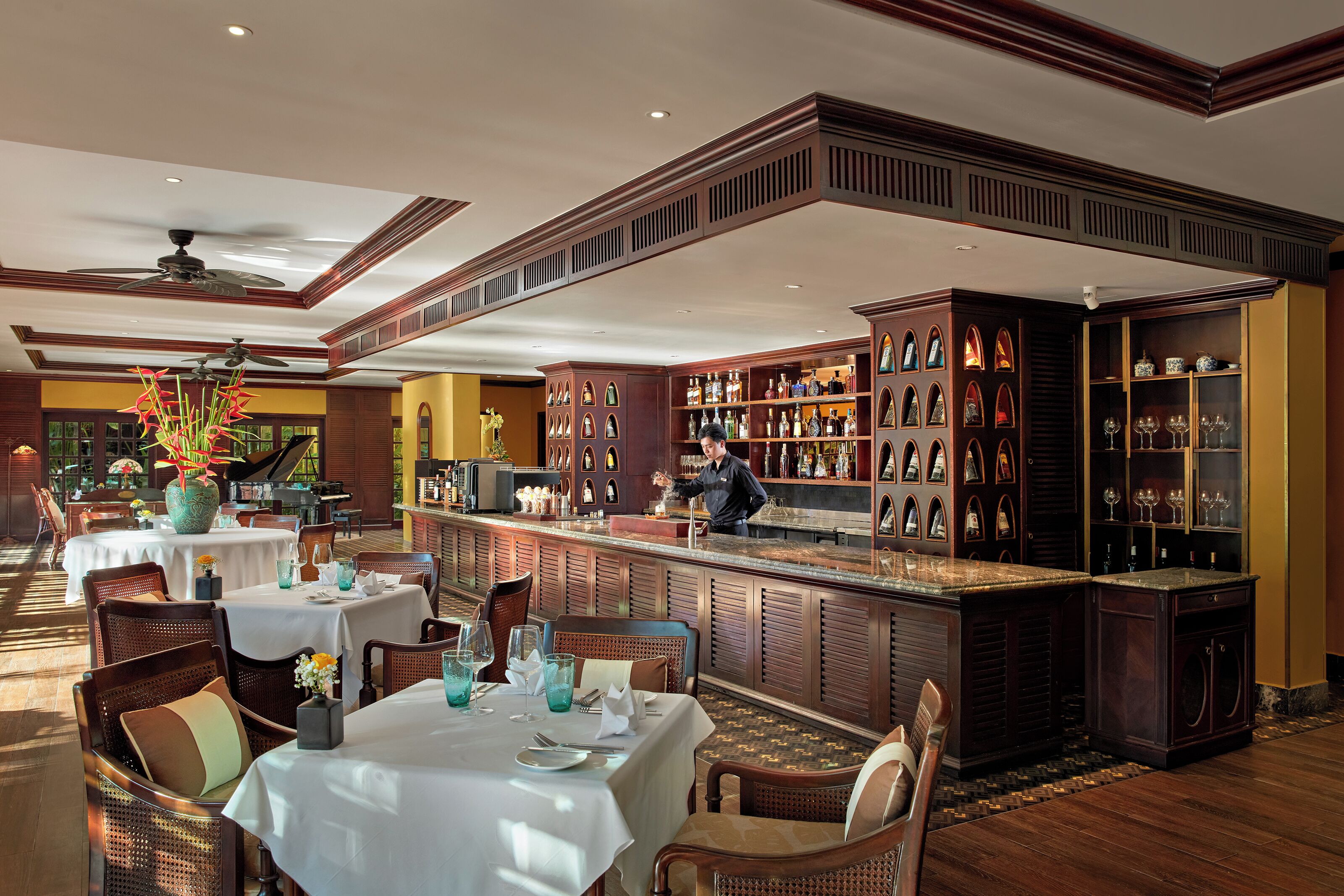 A restaurant with a bar area, wooden furniture, and a piano.
