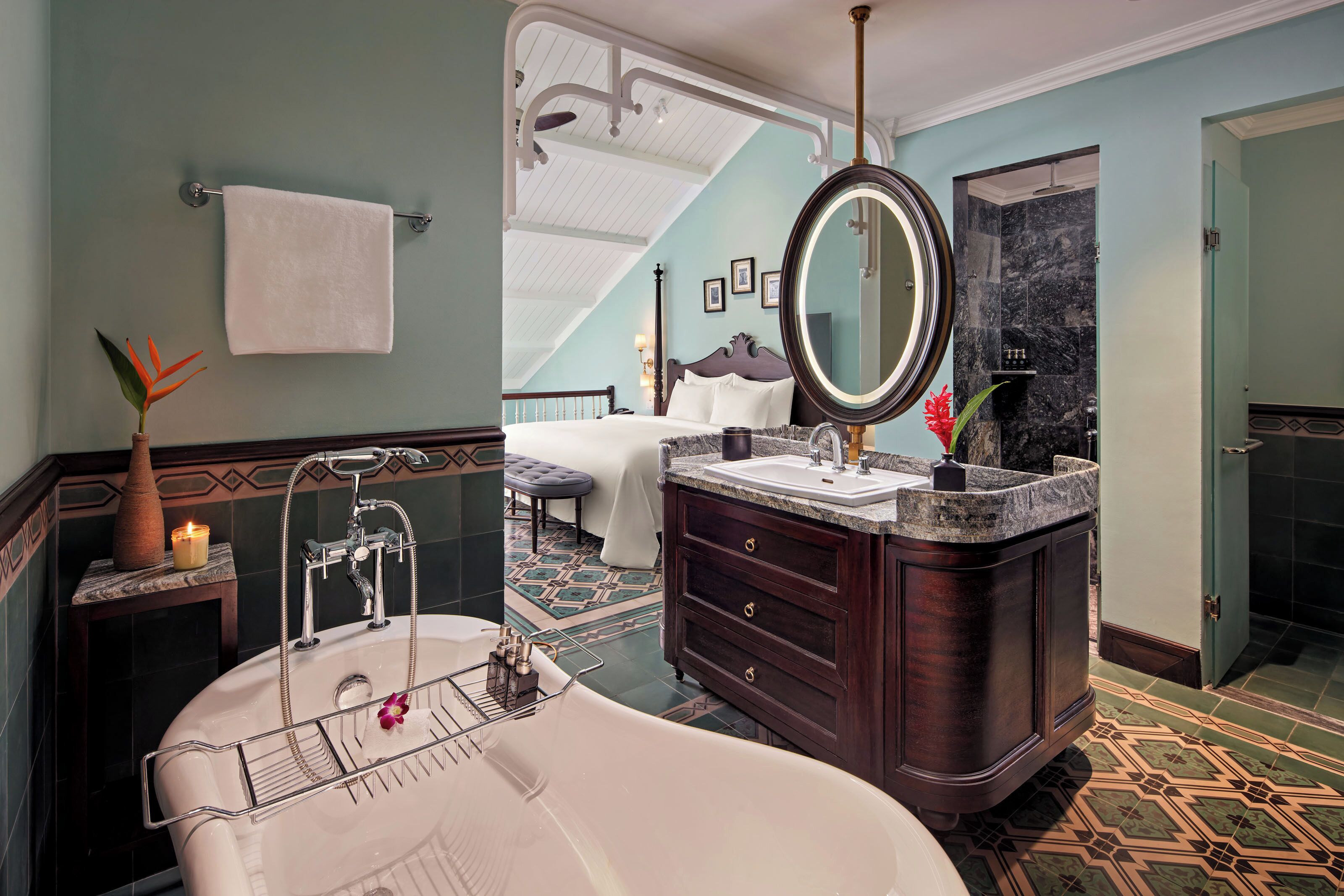 A bathroom with a freestanding bathtub, a vanity with a large mirror, and a shower area.
