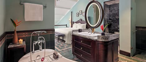 A bathroom with a freestanding bathtub, a vanity with a large mirror, and a shower area.