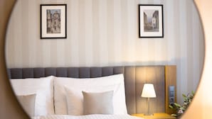 A hotel room with a bed, a nightstand, a lamp, and two framed pictures on the wall. - Hotel Schwaiger (Prague)