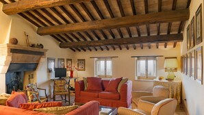 A cozy living room with a fireplace, wooden beams, and comfortable seating. - Scenic Stay in Spoleto (Spoleto)