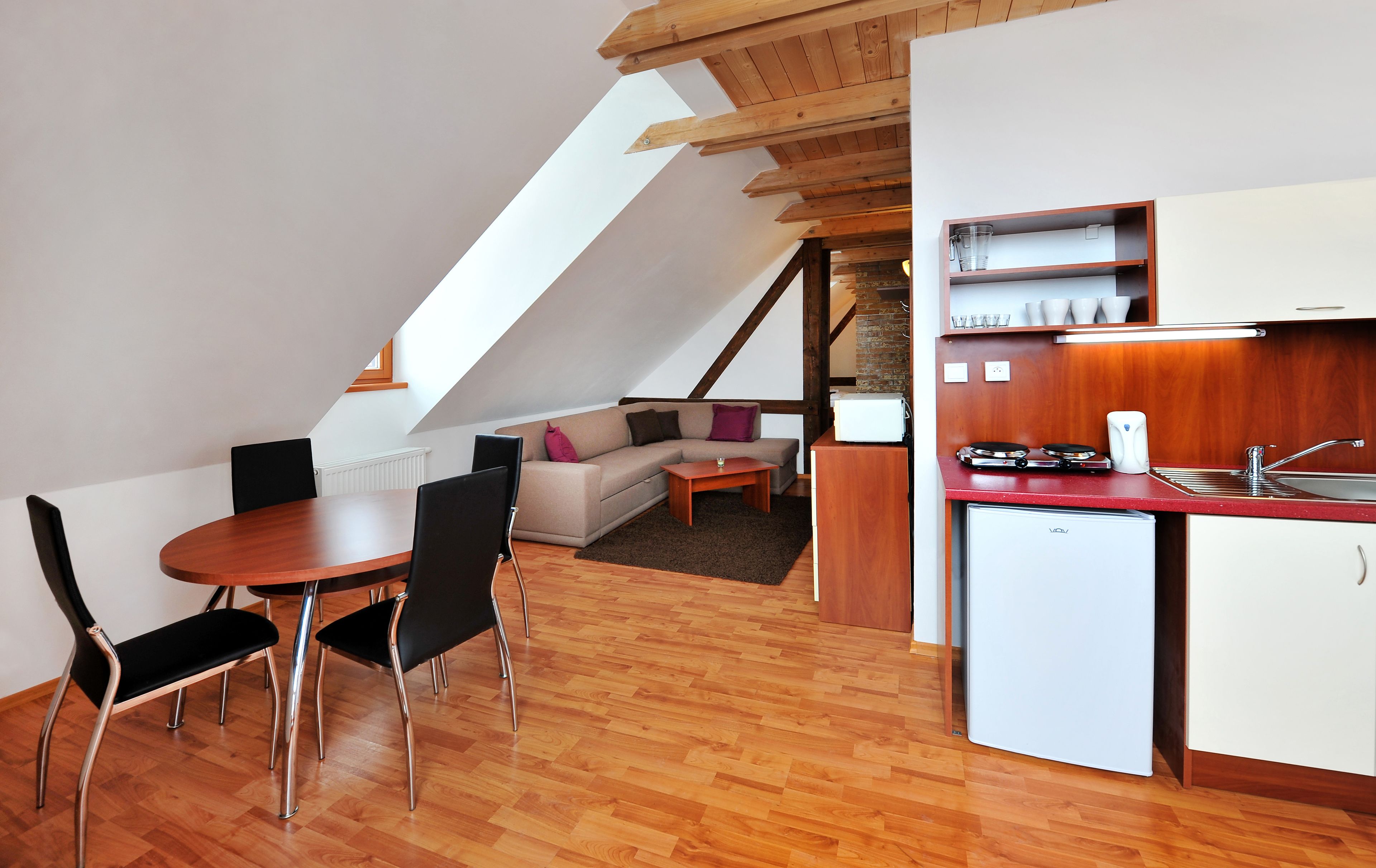 A compact kitchen with a wooden countertop, a sink, and a white refrigerator.