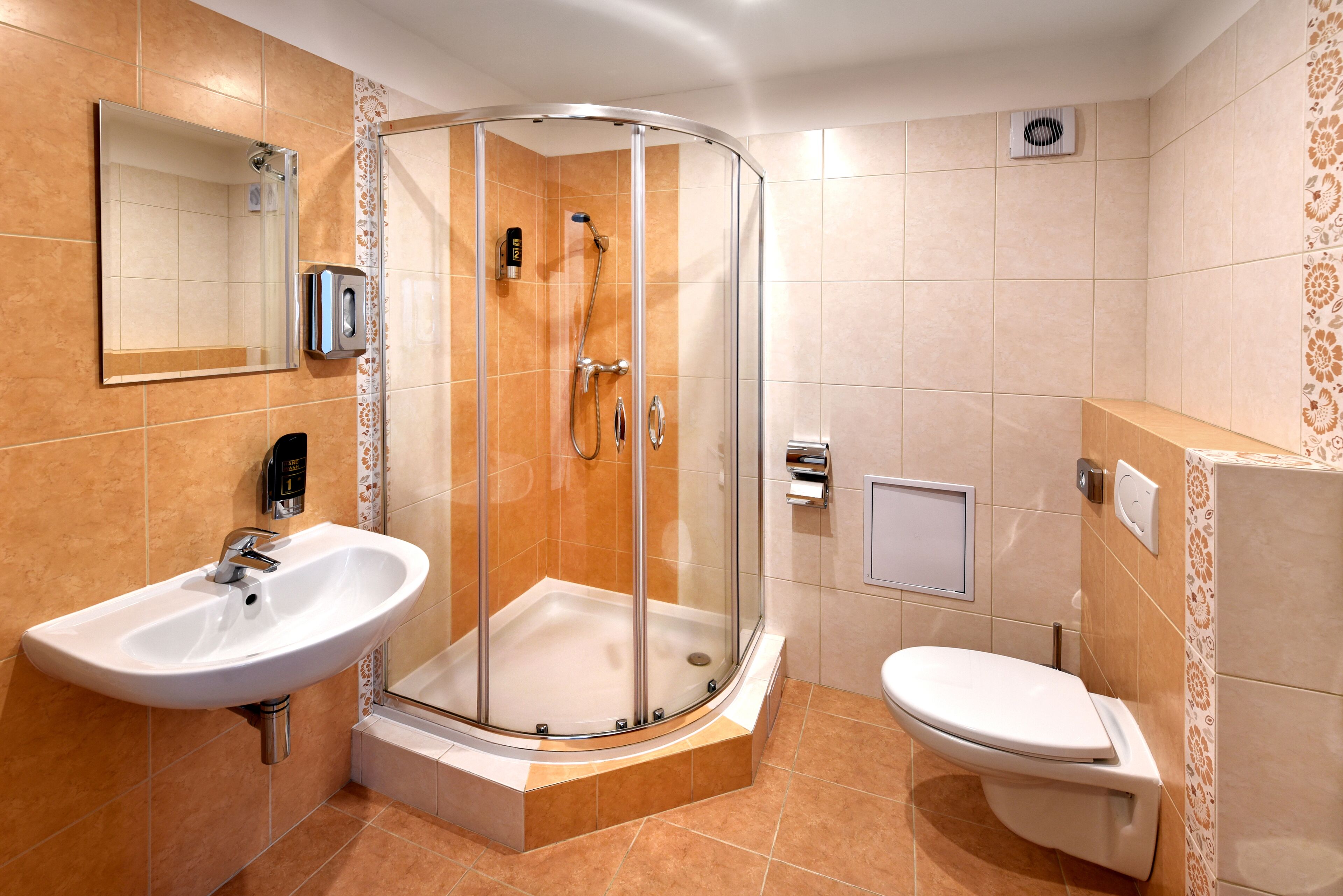 Une salle de bain moderne avec une douche à parois de verre, un lavabo et des toilettes.