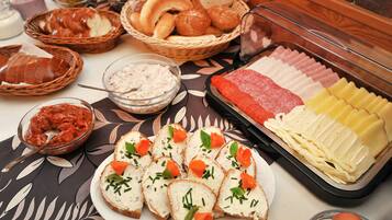 Ein Buffet mit verschiedenen Speisen, darunter Brot, Käse und Fleisch.
