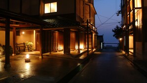 A traditional Japanese street at dusk with buildings illuminated by warm lighting. - Hotel Ichiboukan (Kyotango)