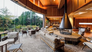Un interior moderno con una chimenea grande, asientos cómodos y vistas al exterior.