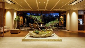 Un interior moderno con un macetero de piedra central, muebles de madera e iluminación empotrada.