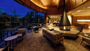 Un interior moderno con una chimenea grande, asientos cómodos y vistas al exterior.