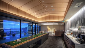 A modern interior with a long counter, seating area, and large windows offering a view of the outdoors. - Kasyouen Bettei Fuka - Adult Only (Kyotango)