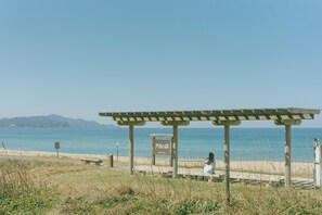A beach with a wooden pergola and a sign. - Kasyouen Bettei Fuka - Adult Only (Kyotango)