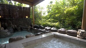 A hot spring area with a stone pool surrounded by rocks and a bamboo fence. - Kasyouen Bettei Fuka - Adult Only (Kyotango)