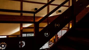 A traditional Japanese interior with wooden beams and tatami mat flooring.