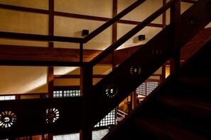 Een traditioneel Japans interieur met houten balken en tatami-matten.