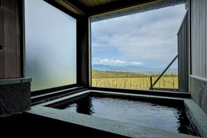 Una habitación con un ventanal grande, un lavabo de piedra y vistas a un viñedo.