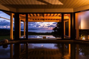 A spacious room with large windows offering a view of the sea and mountains. - Yuhigaura Onsen Ryotei KAI (Kyotango)