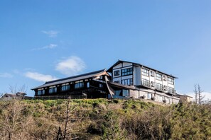 A modern building with a flat roof, large windows, and a balcony on the upper level. - Yuhigaura Onsen Ryotei KAI (Kyotango)