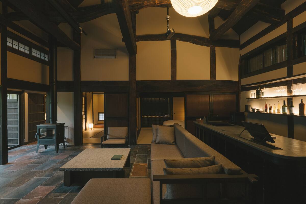 A spacious room with a fireplace, seating area, and a bar with shelves.