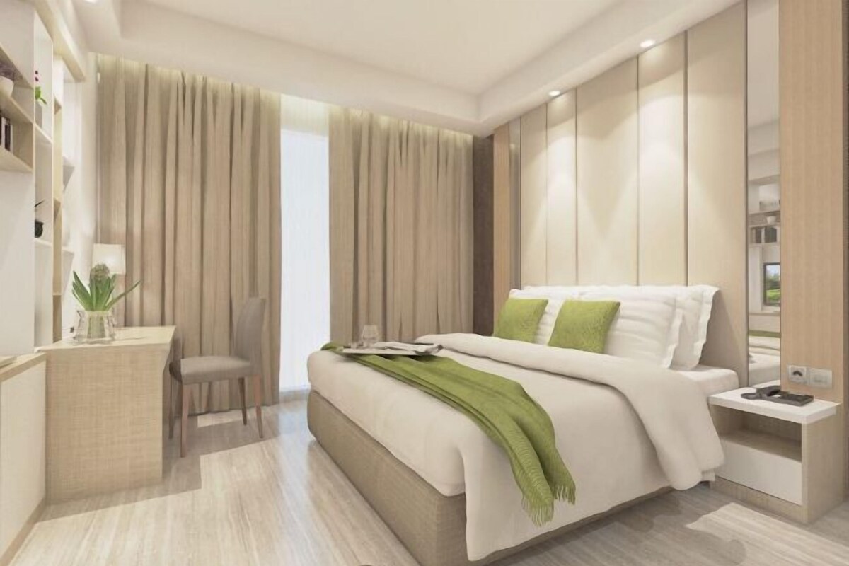 A modern hotel room with a large bed, a desk, and a chair. There is a window with curtains and a view of the outside.
