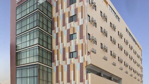 Un hotel de diseño moderno, con una fachada de vidrio destacada y un revestimiento exterior con diseño.