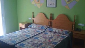Quarto com cama de madeira, duas mesas de cabeceira e paredes verdes.