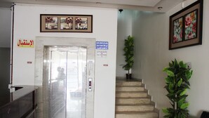An elevator, a staircase, and a reception area with a plant. - Al Eairy Serviced Apartments Company  (Buraydah)