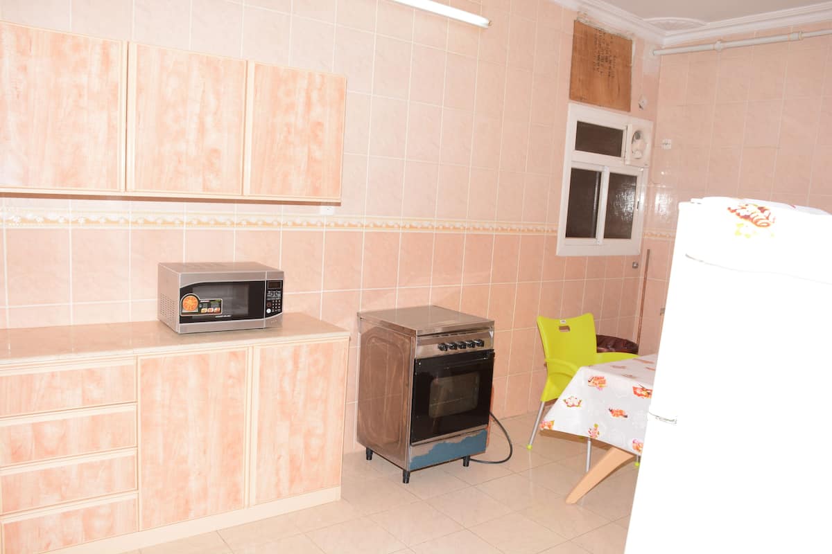 Una cocina equipada con microondas, horno y refrigerador.