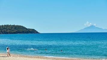 Di pantai, kursi berjemur, payung pantai, dan handuk pantai