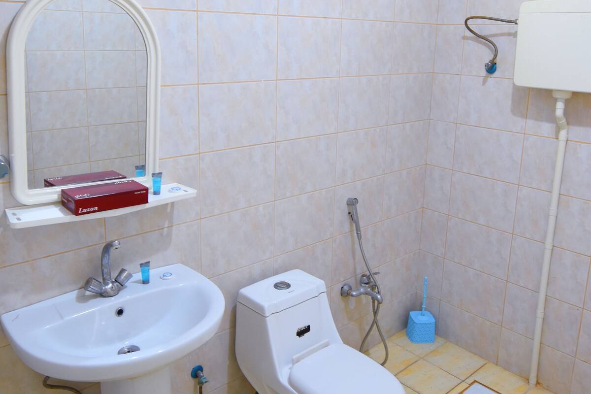 Un baño pequeño con lavamanos, inodoro y ducha.