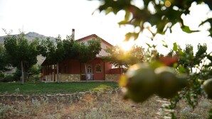 A house with a stone facade, a red roof, and a garden with a stone pathway. - Agrotospita Country Houses (Nafplio)