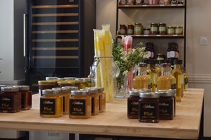 A display of honey jars and honey bottles on a wooden table. - Hôtel et Appartements Les Platanes (Thueyts)
