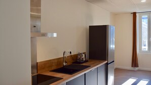 Eine moderne Küche mit einer Edelstahl-Dunstabzugshaube, einem Backofen und einem Kühlschrank.