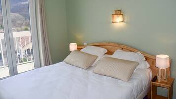 Un lit bien fait, avec deux oreillers, une tête de lit en bois et des lampes de chevet.
