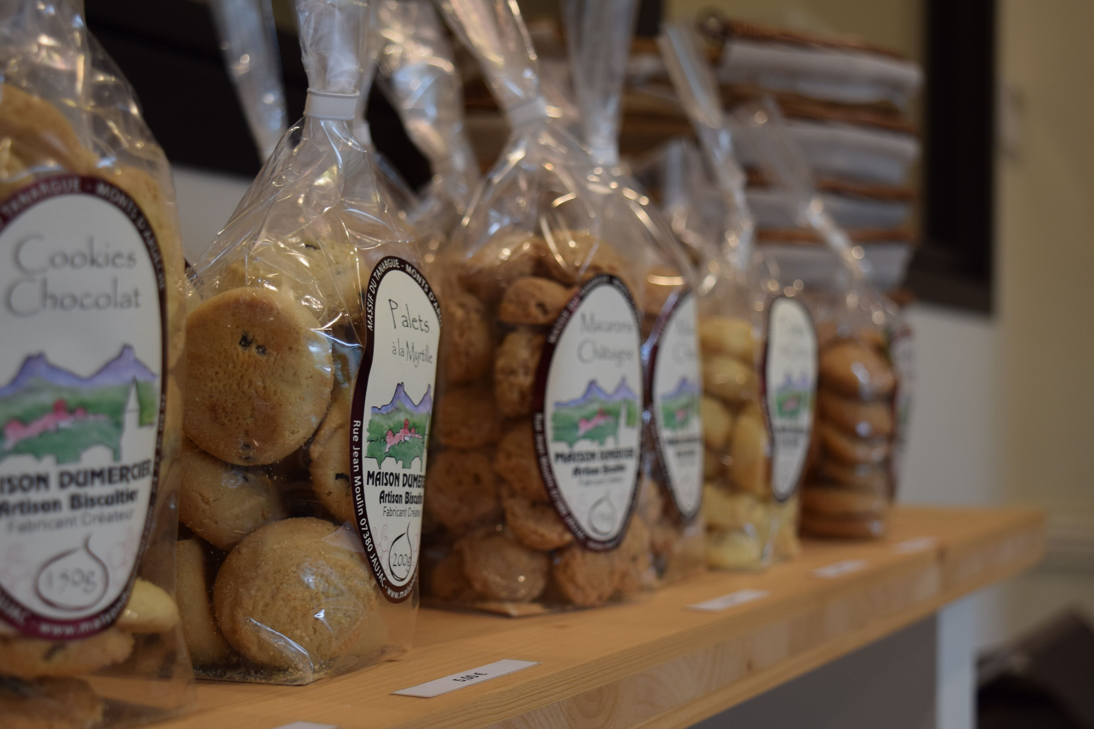 A display of packaged cookies on a wooden shelf.