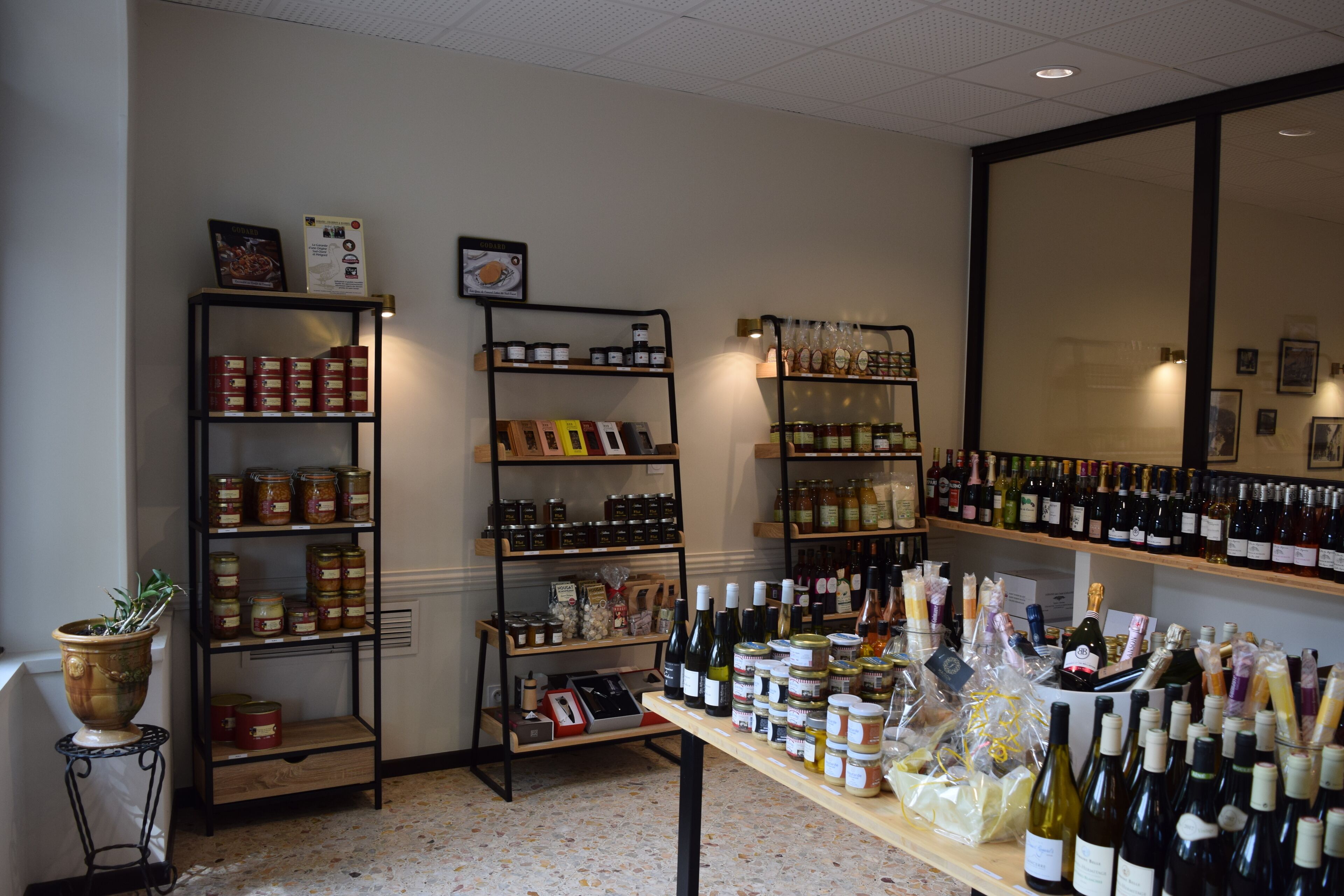 Una tienda de vinos con estantes llenos de botellas y frascos de conservas.