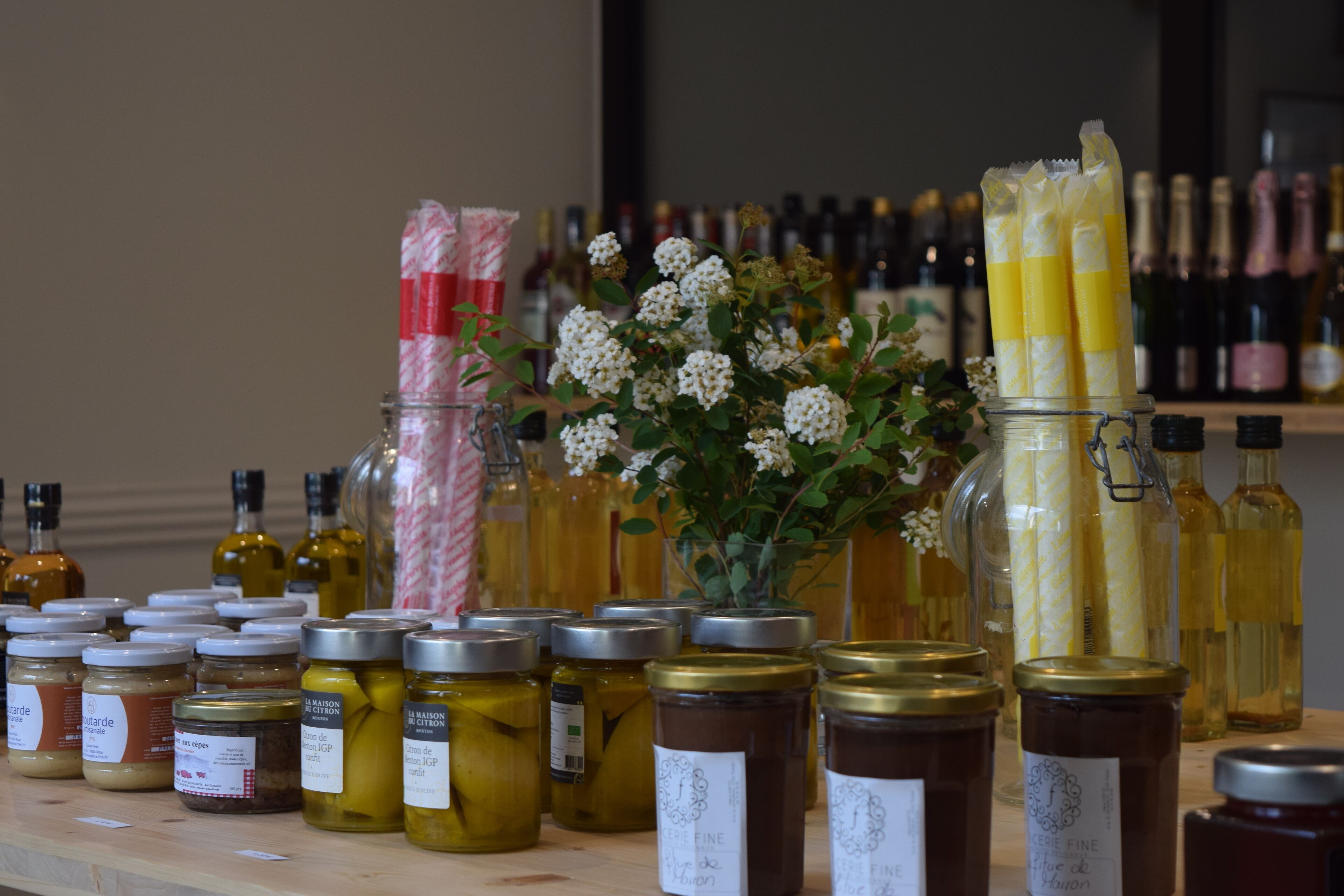 A variety of jars and bottles, likely containing food items or condiments, arranged on a wooden surface.