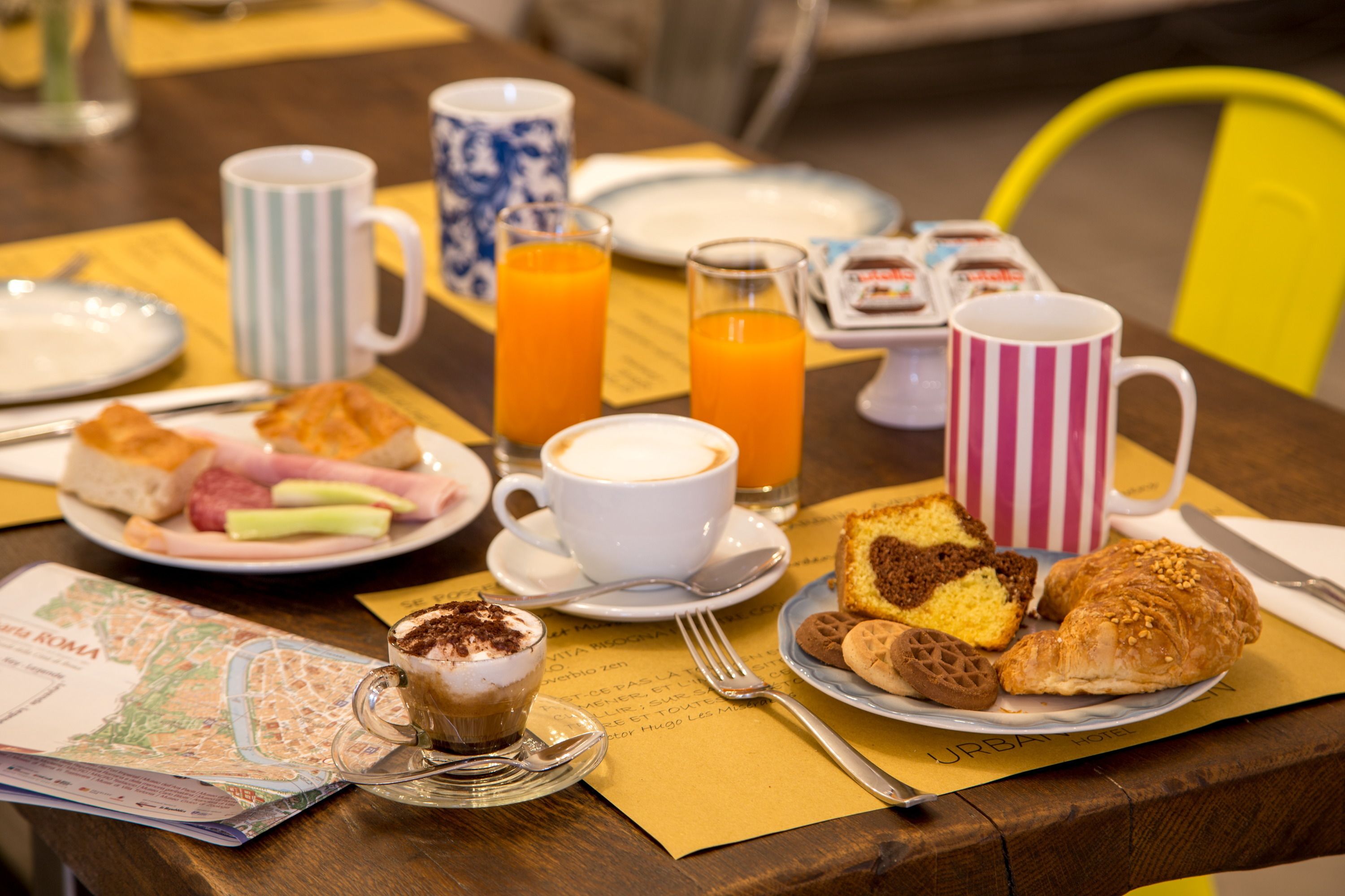 Un desayuno con diferentes alimentos, bebidas y un mapa sobre la mesa.