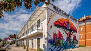 A building with a mural of a tree and flowers on its side, labeled "URBAN GARDEN HOTEL & BAR". - Urban Garden Hotel (Rome)