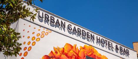 Un edificio con un cartel que dice "URBAN GARDEN HOTEL & BAR".