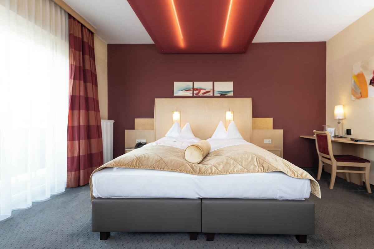Una habitación de hotel con cama, escritorio y silla.
