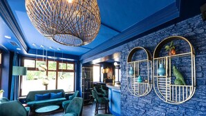 Ein Zimmer mit blauer Wand, einer Pendelleuchte und einer Bar.