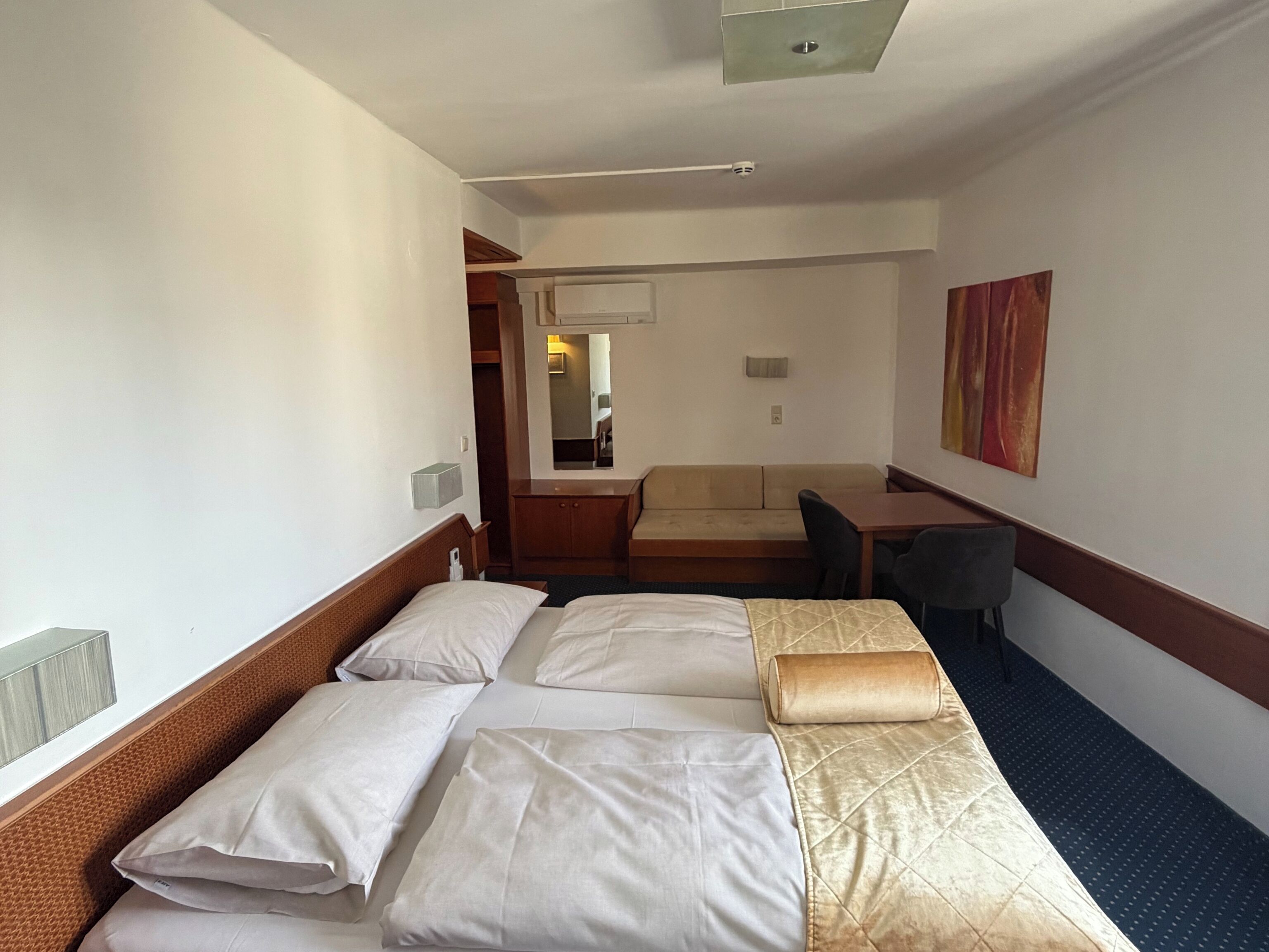 Triple room with Balcony | Een minibar, een kluis op de kamer, een bureau, geluiddichte muren