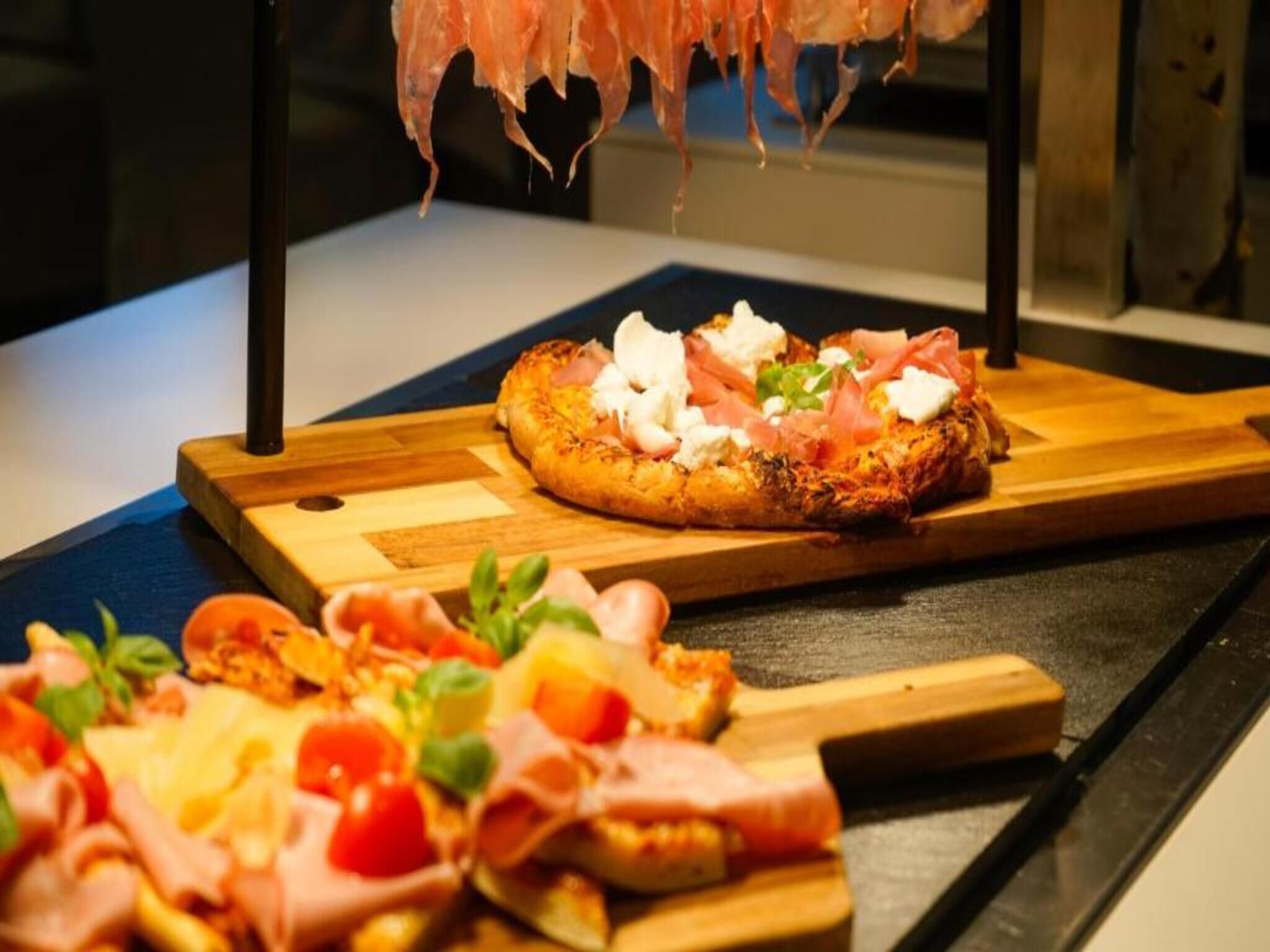 Una pizza con ingredientes sobre una tabla de madera.