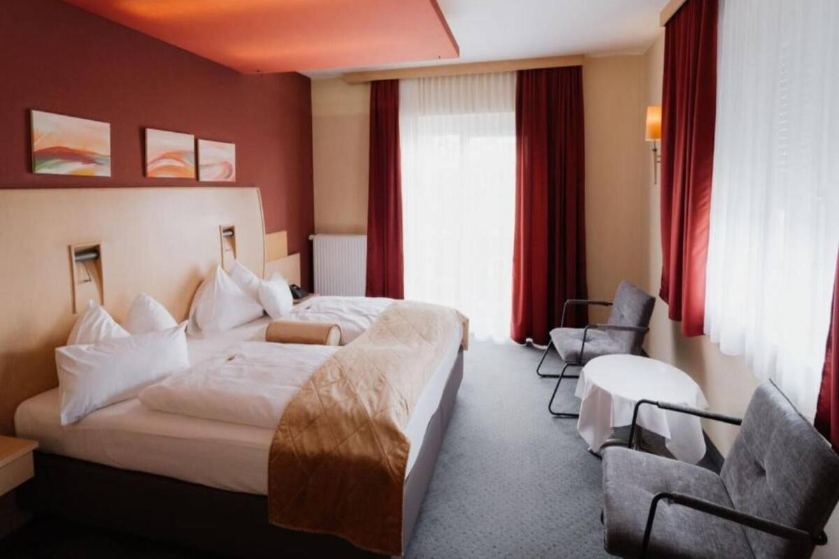 Una habitación de hotel con cama, escritorio y silla.