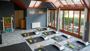 A gym with multiple workout stations, skylights, and large windows.